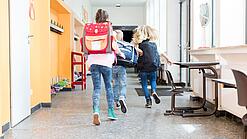 Kinder rennen auf dem Flur einer Schule.