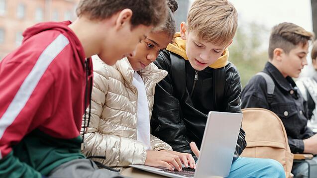 Gruppe Kinder vor einem Laptop