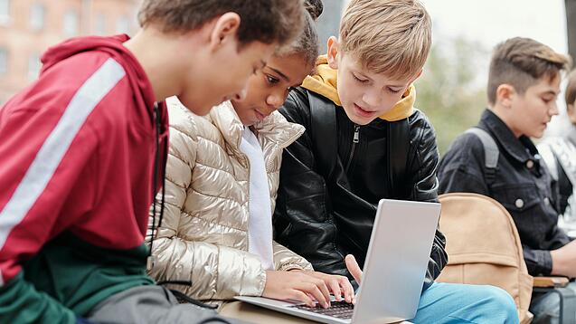 Gruppe Kinder vor einem Laptop