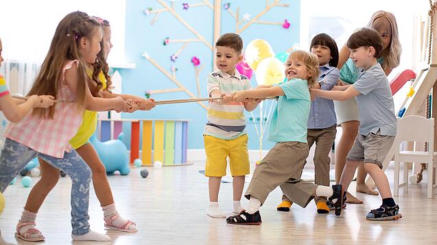 Kleinkinder ziehen an zwei Seiten eines Seils.