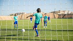 Kinder spielen Fußball auf einem Fußballplatz.