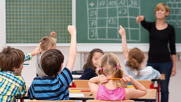 Schulklasse und Lehrerin im Unterricht.