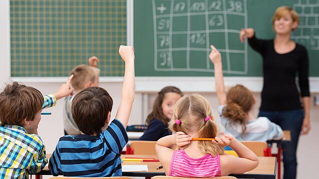 Schulklasse und Lehrerin im Unterricht.