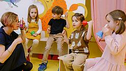 Eine Erzieherin spielt mit kleinen Kindern in einer Kita.
