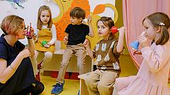 Eine Erzieherin spielt mit kleinen Kindern in einer Kita.