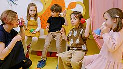 Eine Erzieherin spielt mit kleinen Kindern in einer Kita.
