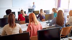 Junge Erwachsene sitzen in einem Computerraum.