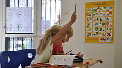 Eine Grundschülerin und ein Grundschüler sitzen im Unterricht.
