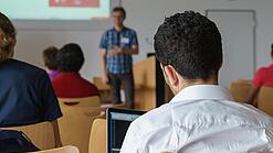 Ein Student hört sich einen Vortrag eines Dozenten an.