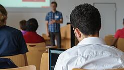 Ein Student hört sich einen Vortrag eines Dozenten an.