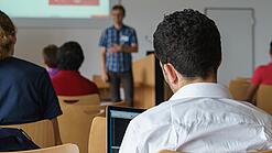 Ein Student hört sich einen Vortrag eines Dozenten an.