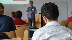 Ein Student hört sich einen Vortrag eines Dozenten an.