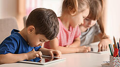 Kleine Kinder spielen am Tablet.