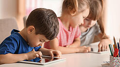 Kleine Kinder spielen am Tablet.