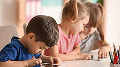 Kleine Kinder spielen am Tablet.