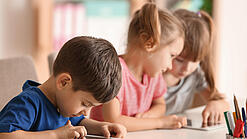 Kleine Kinder spielen am Tablet.