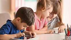Kleine Kinder spielen am Tablet.