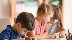 Kleine Kinder spielen am Tablet.