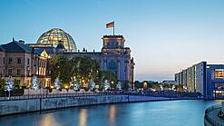Blick auf das Berliner Reichstagsgebäude in der Dämmerung.