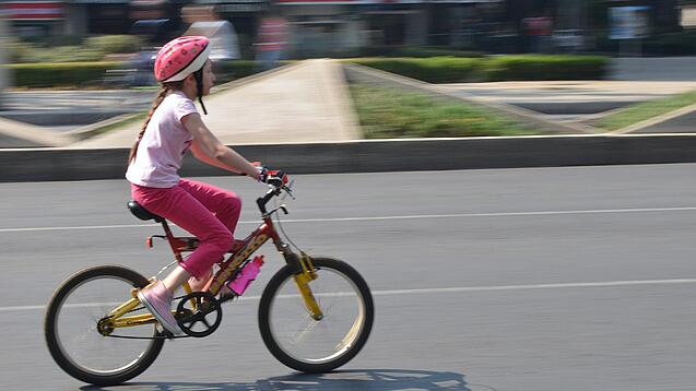 Ein Kind fährt auf einem Fahrrad.