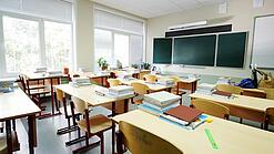 Leeres Klassenzimmer mit Tafel, Tischen und Stühlen