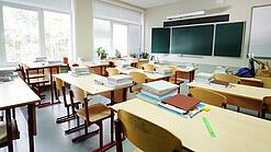Leeres Klassenzimmer mit Tafel, Tischen und Stühlen