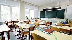 Leeres Klassenzimmer mit Tafel, Tischen und Stühlen