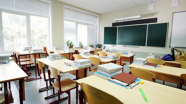 Leeres Klassenzimmer mit Tafel, Tischen und Stühlen