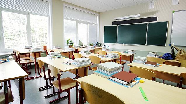 Leeres Klassenzimmer mit Tafel, Tischen und Stühlen