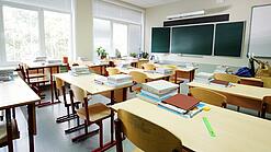 Leeres Klassenzimmer mit Tafel, Tischen und Stühlen