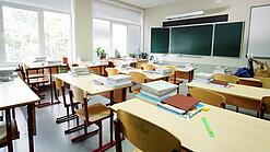 Leeres Klassenzimmer mit Tafel, Tischen und Stühlen