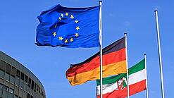 Flaggen von Europa, Deutschland und Nordrhein-Westfalen wehen im Wind.