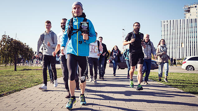 Eine Gruppe von Menschen joggt auf einem Weg.