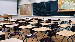 Ein leeres Klassenzimmer mit Stühlen und Pulten.