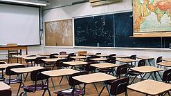 Ein leeres Klassenzimmer mit Stühlen und Pulten.