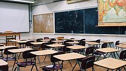 Ein leeres Klassenzimmer mit Stühlen und Pulten.