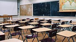 Ein leeres Klassenzimmer mit Stühlen und Pulten.