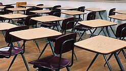 Ein leeres Klassenzimmer mit Stühlen und Pulten.