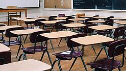 Ein leeres Klassenzimmer mit Stühlen und Pulten.