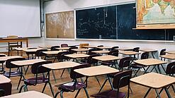 Ein leeres Klassenzimmer mit Stühlen und Pulten.