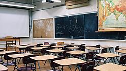 Ein leeres Klassenzimmer mit Stühlen und Pulten.