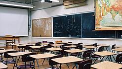 Ein leeres Klassenzimmer mit Stühlen und Pulten.