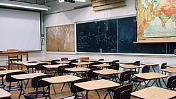Ein leeres Klassenzimmer mit Stühlen und Pulten.
