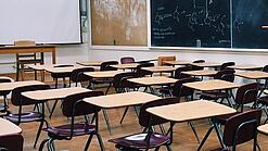 Ein leeres Klassenzimmer mit Stühlen und Pulten.