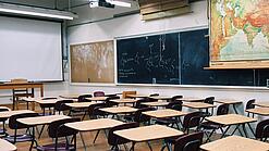 Ein leeres Klassenzimmer mit Stühlen und Pulten.