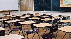 Ein leeres Klassenzimmer mit Stühlen und Pulten.