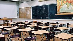 Ein leeres Klassenzimmer mit Stühlen und Pulten.