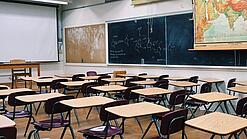 Ein leeres Klassenzimmer mit Stühlen und Pulten.