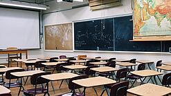 Ein leeres Klassenzimmer mit Stühlen und Pulten.