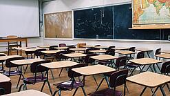 Ein leeres Klassenzimmer mit Stühlen und Pulten.